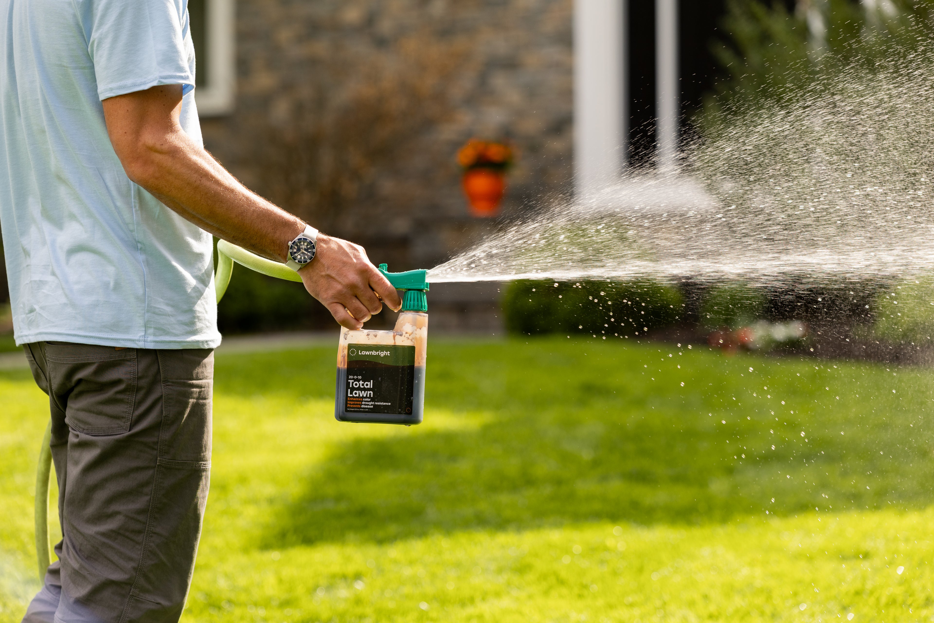 Person using a lawn sprinkler to water grass